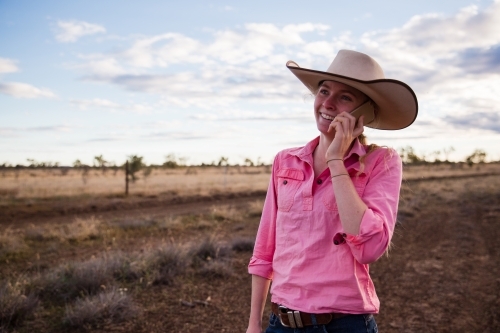 Young female farmer holding phone to her ear