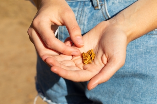 young female hands holding gold nugget - Australian Stock Image
