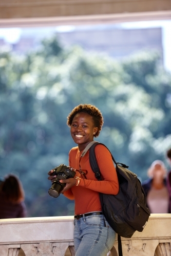 Young female photographer holding digital camera - Australian Stock Image