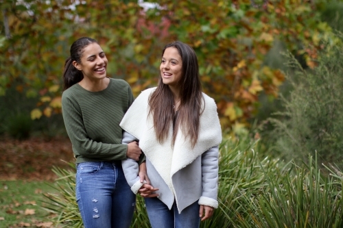 Young female same sex couple walking hand in hand - Australian Stock Image