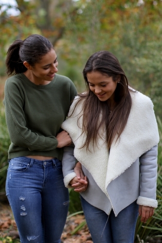 Young female same sex couple walking hand in hand - Australian Stock Image