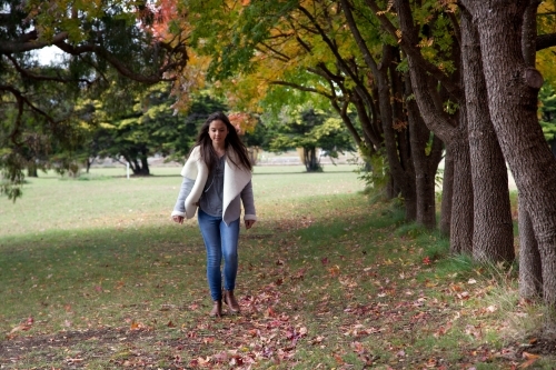 Young female walking alone in a park - Australian Stock Image