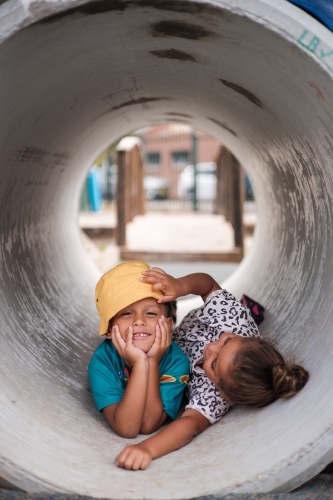 Young First Nations girl and boy playing together in a tunnel - Australian Stock Image