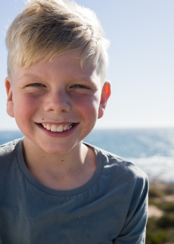 Young fresh faced boy smiling on a sunny day - Australian Stock Image