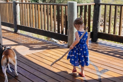 Young girl carrying a piece of drift wood - Australian Stock Image