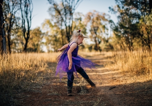 Young girl dancing and spinning on regional property