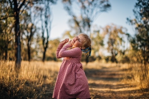 Young girl dancing outside in bushland - Australian Stock Image