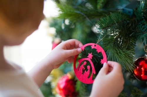 Young girl decorating a christmas tree