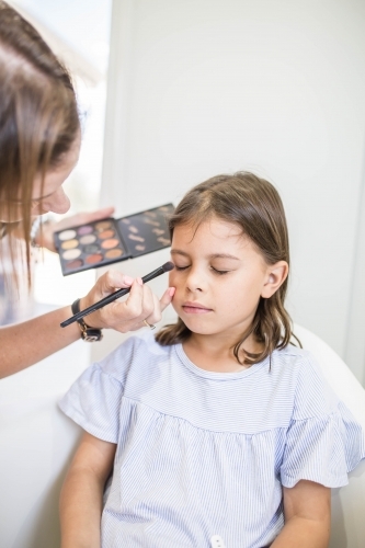 Young girl getting eye makeup done - Australian Stock Image