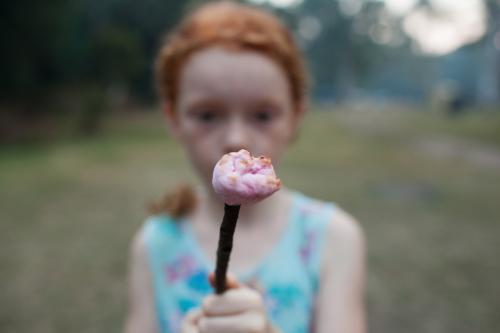 Young girl holding a toasted marshmallow - Australian Stock Image