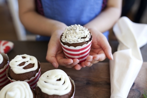 Young girl holding decorated cupcake in her hands