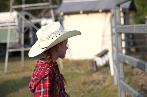 Young girl in a check shirt and cowboy hat - Australian Stock Image