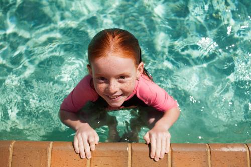 Young girl in a swimming pool looking up