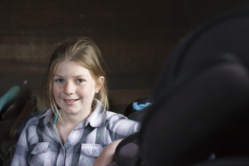 Young girl in dark shed - Australian Stock Image