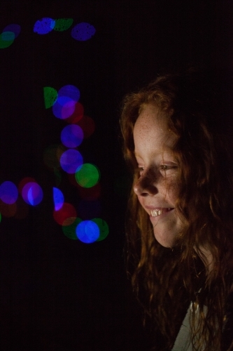 Young girl in low light with coloured lights