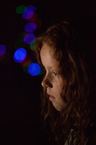 Young girl in low light with coloured lights - Australian Stock Image