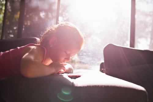 Young girl looking at a device - Australian Stock Image