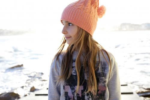 Young girl looking away with beach behind her - Australian Stock Image