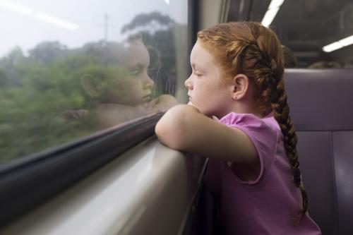 Young girl looking out the window of a train