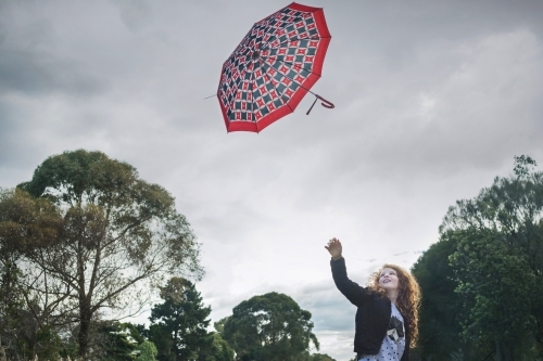 Young girl losing her umbrella on a windy winter day - Australian Stock Image