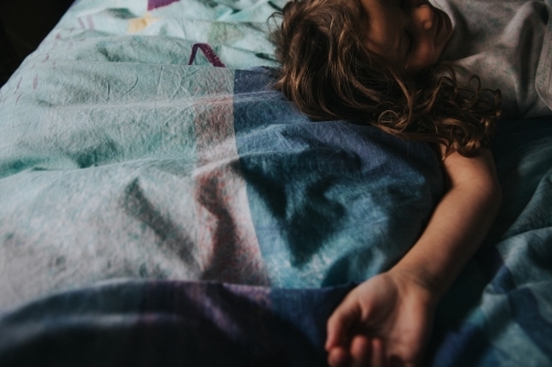 Young girl lying quietly on bed