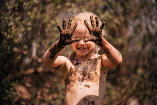 Young girl showing muddy hands - Australian Stock Image
