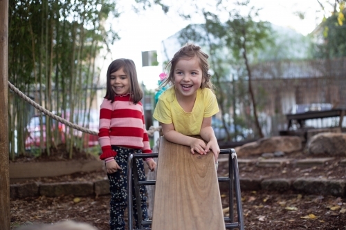Young girl on wooden see-saw - Australian Stock Image