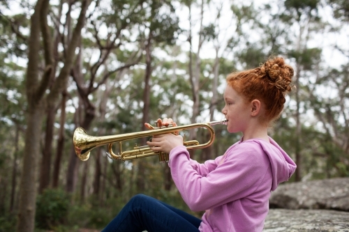 Young girl playing a trumpet - Australian Stock Image