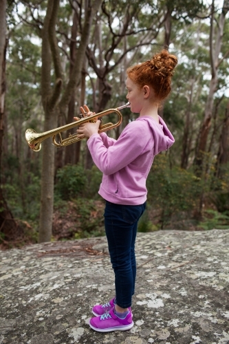 Young girl playing a trumpet outside - Australian Stock Image