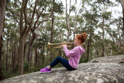 Young girl playing a trumpet outside - Australian Stock Image