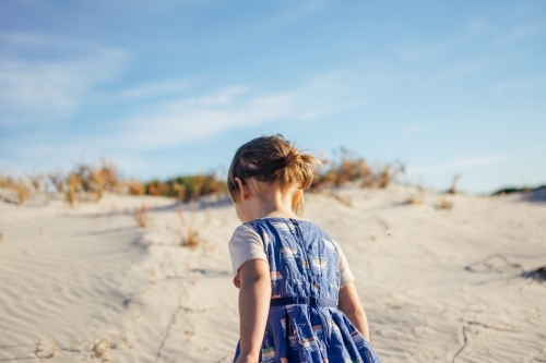 Young girl playing in sand dunes