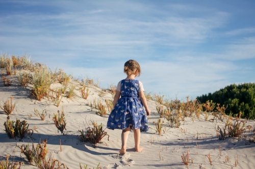 Young girl playing in sand dunes - Australian Stock Image