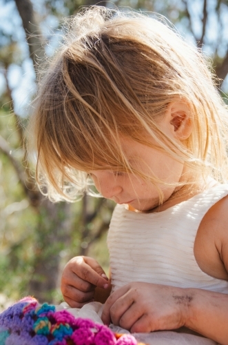 Young girl playing outdoors in a white dress - Australian Stock Image