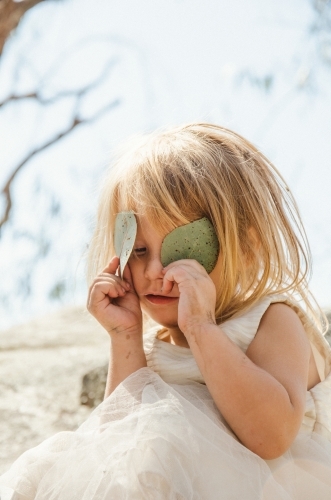 Young girl playing with gumleaves