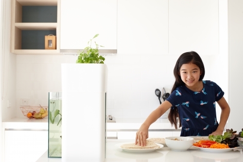 Young girl preparing healthy lunch in kitchen