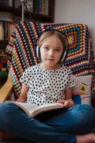 Young girl reading a book at home - Australian Stock Image