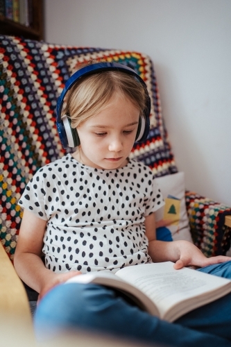 Young girl reading a book at home - Australian Stock Image