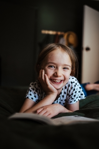 Young girl reading a book at home