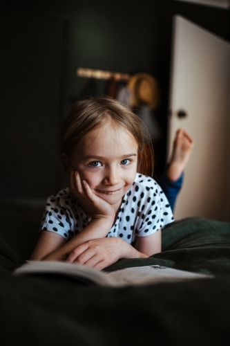 Young girl reading a book at home - Australian Stock Image