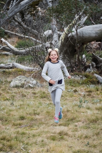 Young girl running in the country side. - Australian Stock Image