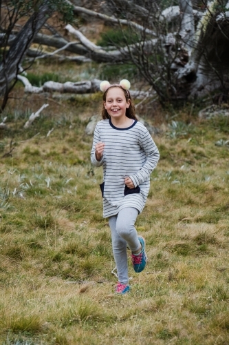 Young girl running in the country side. - Australian Stock Image