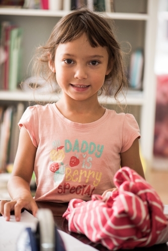 Young girl smiling at camera indoors. - Australian Stock Image