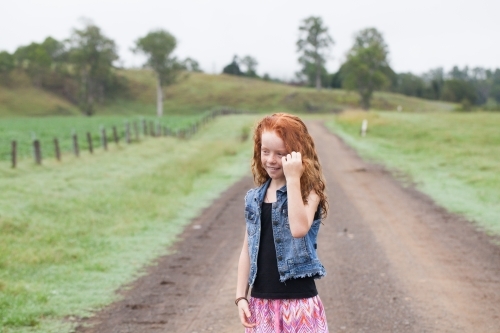 Young girl standing on a dirt road - Australian Stock Image
