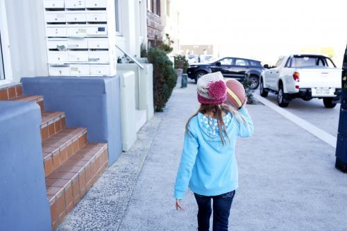 Young girl walking down street with basketball - Australian Stock Image