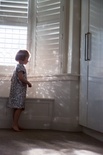 Young girl wearing a sparkly dress playing with the reflected light