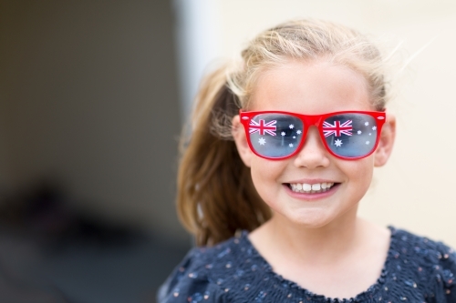 Young girl wearing Australian Flag sunglasses for Australia Day - Australian Stock Image