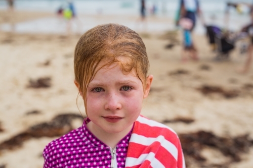 young girl with bloodshot eyes and messy hair after being dumped by a wave