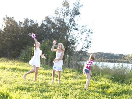 Young girls chasing bubbles outside