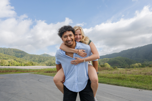 Young in love mixed race couple smiling during a piggyback ride - Australian Stock Image