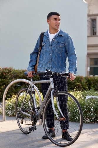 Young Indigenous Australian man at park with bicycle